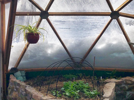 Inside a Growing Dome in winter, with the insulated north wall and a raised bed