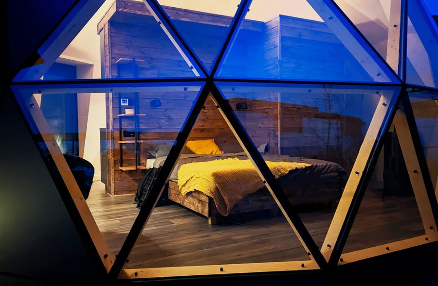A GeoHome bedroom at dusk, seen through the window panels