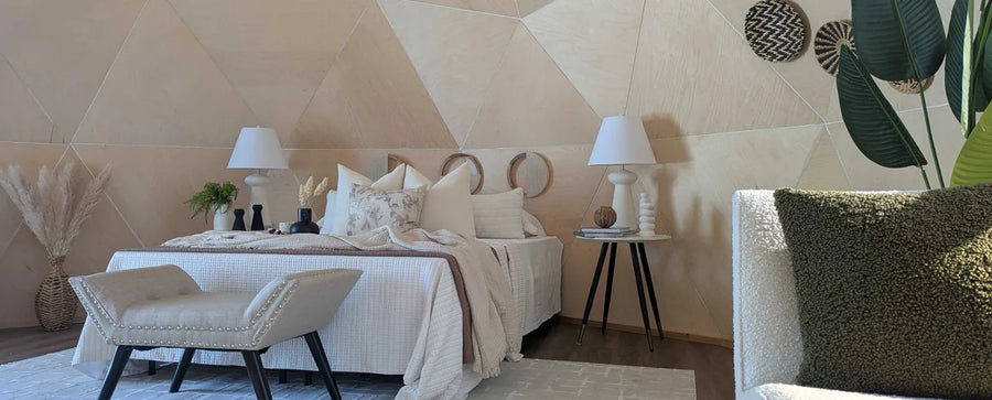 A GeoHome bedroom with a bench at the foot of the bed