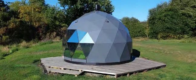 A grey GeoHome on a timber deck in a sunny field