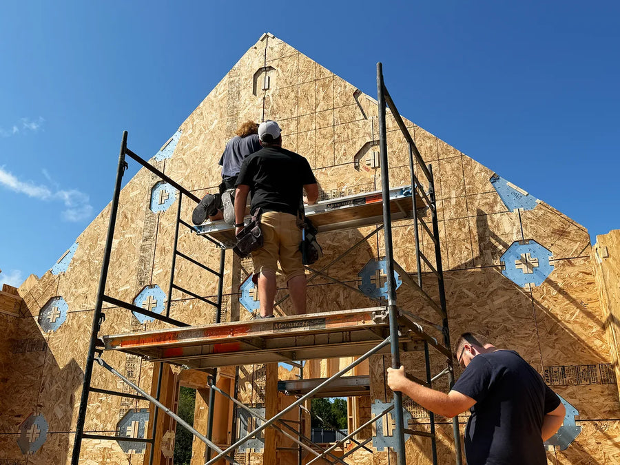 Builders on scaffolding assembling a LockFrame wall