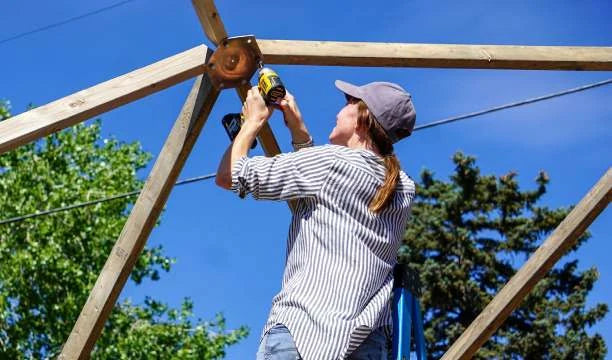 A builder fastening dome frame struts with a cordless drill